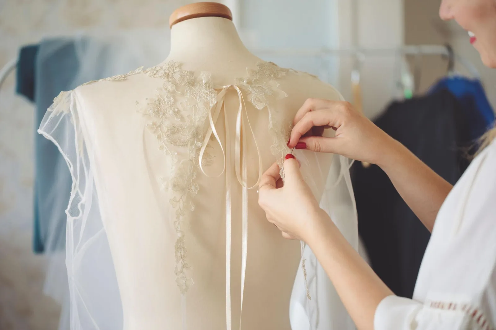 Seamstress hand-finishing lace on a wedding dress at Mayller Bridal atelier, Pennsylvania